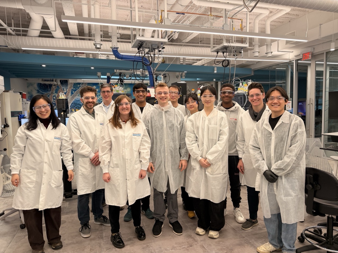 HTGAA cohort in lab coats inside the lab