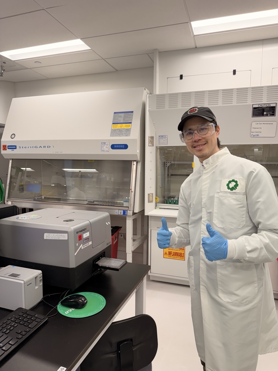 Sean in the lab at the Synergy plate reader and SterilGARD biosafety cabinet